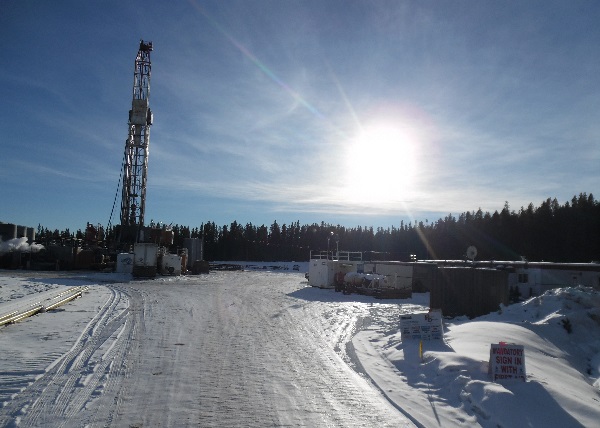 Oilfield Trucking. Arriving at a drilling rig in remote area. Notice the worker camp on the right.