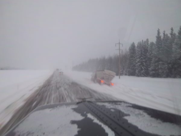 Oilfield accidents - A loaded set of hopper bottom b-trains with frac sand slides off the hwy