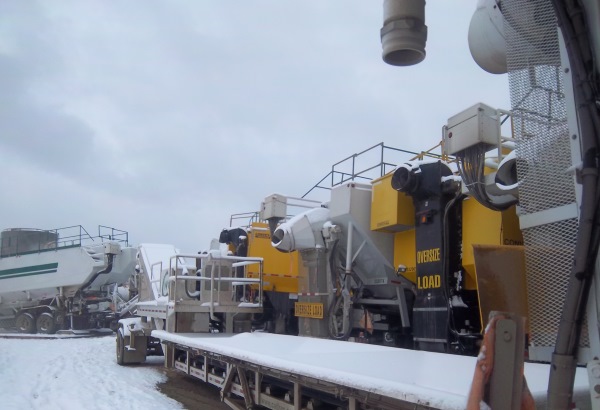 Frac sand storage on location. Multiple t-belts being used for a large frac job set up in sequence to feed the blender unit.