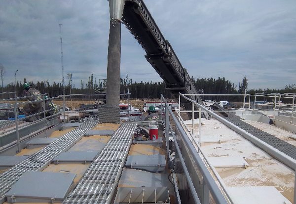 Frac sand unloading with a telebelt. Multiple stacked sand vessels can be hard to reach with pneumatic pressurized lines. Telebelts can easily access and refill the vessels.