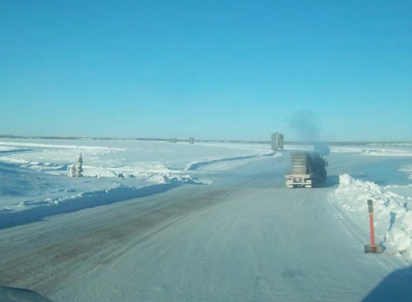 Ice road driving photos. 3 heavy haulers with 35 foot high tanks rolling into Lockhart Lake base camp.