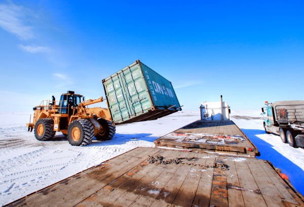 Ice Road Loads. Loader unloading containers at the mine